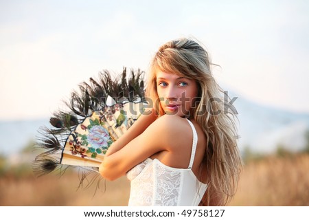 The young woman with a fan on a mountain background.