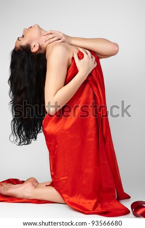 Beautiful young woman is covered with red cloth.