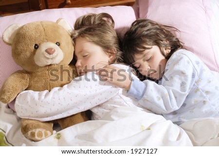two small girls sleeping with a plush bear