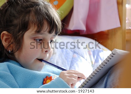 little  girl reading  and biting a pencil over a bed