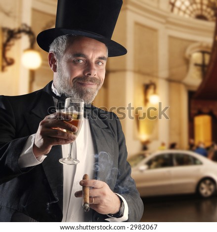 a man wearing a smoking holding a glass and cigar, against a luxury blurry background