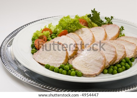 A pork loin roast on dish over a white background
