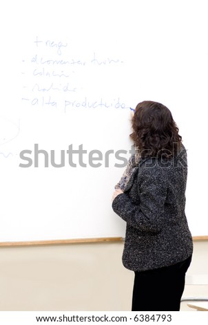 a female teacher writing on a white board
