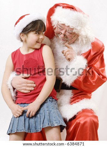 little girl talking with an old santa claus