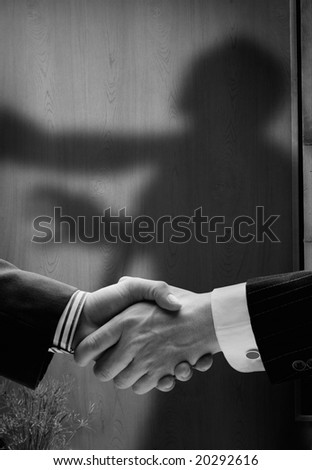 business handshake with shadows behind showing  real intentions, showing a man being hanged by the neck