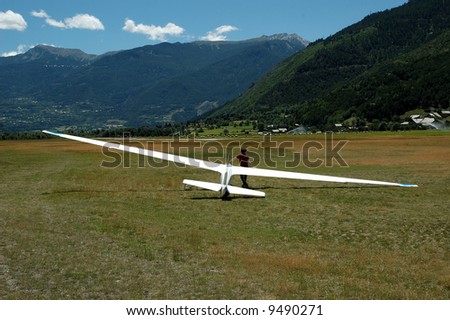 A pilot and his Glider are waiting for the next plane to haul them up in the sky.