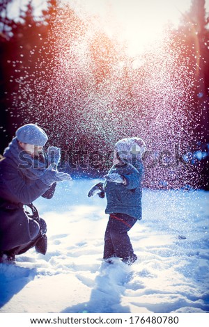 Happy family playing with snow in winter.