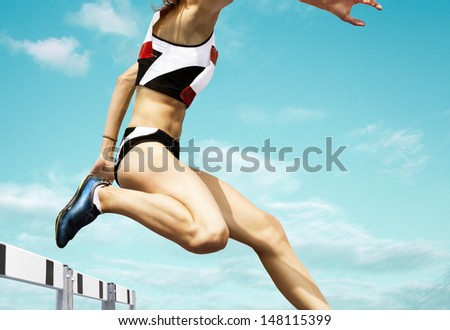 Female Hurdle Runner Leaping Over The Hurdle