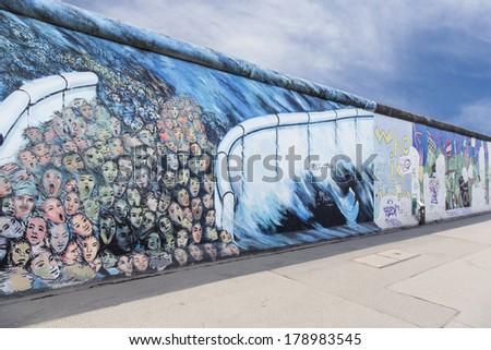 BERLIN - JANUARY 13, 2014 : The East Side Gallery is the largest outdoor art gallery in the world. Here it shows people, who break out through a gap of the wall. Artist was Kani Alavi.