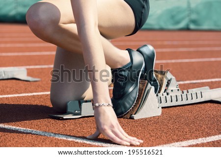 Female runner in start position is ready to start the race