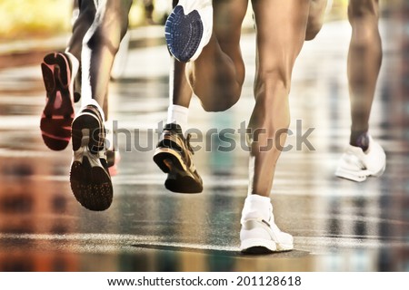 Runners on wet ground with city reflection