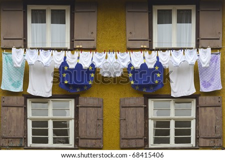 Timber framing house with europe flag colored laundry hanging on a clothesline