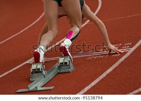 Female short distance runner  is in start position