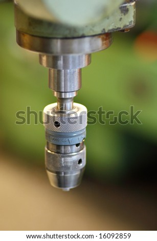 Close-up of the chuck on a large metal drilling machine.