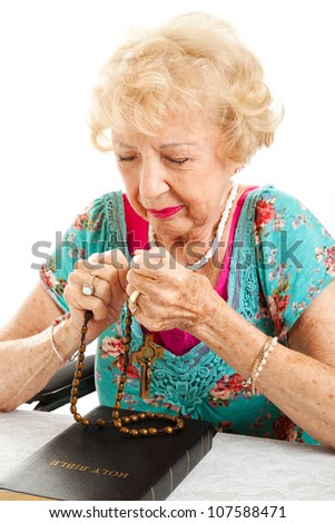Catholic, Christian elderly woman with her bible, praying the rosary.  White background.