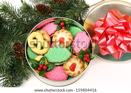 Gift of homemade Christmas cookies in a decorative tin, under the Christmas tree.