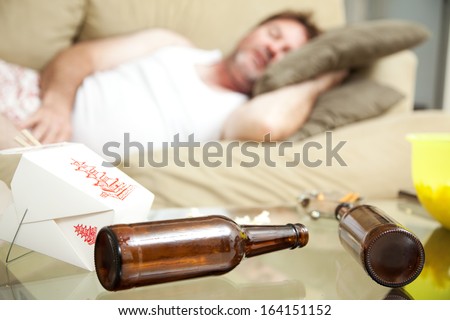 Man passed out on his couch in his underwear.  A full ashtray, empty beer bottles and empty Chinese take out container scattered on his coffee table.