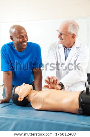 African-american adult student learning first aid CPR from a doctor.