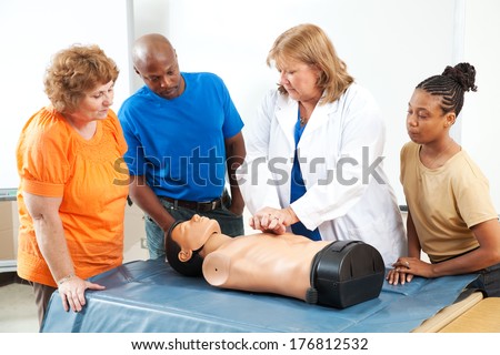 Adult education students learning CPR and first aid from a doctor or nurse.