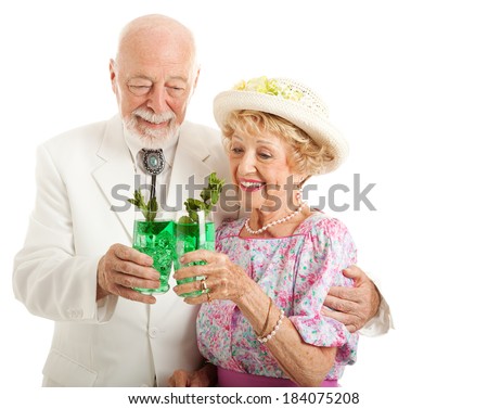 Southern senior couple enjoying traditional mint julep coctails to celebrate the Kentucky Derby.  Isolated on white.