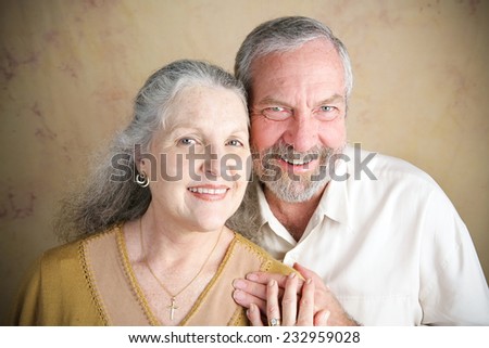 Beautiful senior Christian couple.  She is wearing a cross and wedding.  Portrait illustrating traditional family values.  Slight vignette added for emphasis.