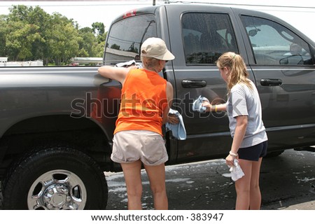 A mother and daughter washing Dad\'s truck.