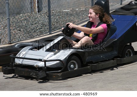 A young having fun racing a go cart around a track