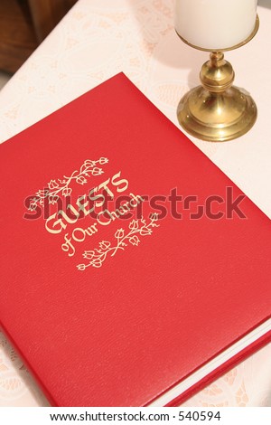 a red church guest book on a table, closed.