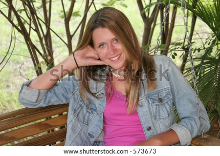 stock photo A beautiful shy teen girl on a porch swing