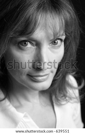 A closeup of a beautiful woman with green eyes and an intense expression.