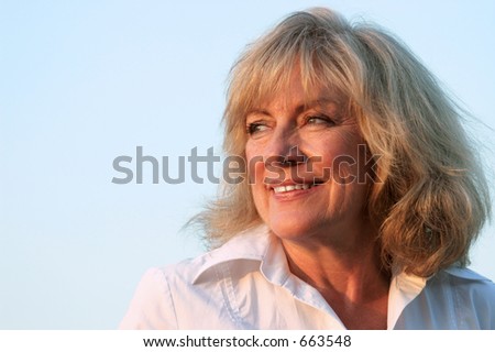 A beautiful, mature woman looking into the late day sun, facing her future.