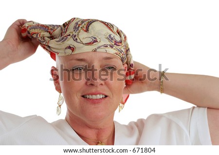 A beautiful woman, bald from chemotherapy,  prepares to remove the scarf covering her head.  Second in a sequence.