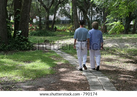 A couple walking together on garden path.