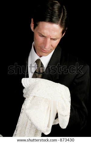 stock photo A groom left at the altar or grieving widower holding the