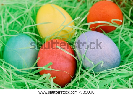 A closeup of colored Easter eggs in easter grass.