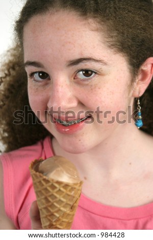 stock photo A cute teen girl with freckles and braces holding a chocolate
