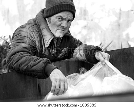 A homeless man rooting in a dumpster for food. Black and White.