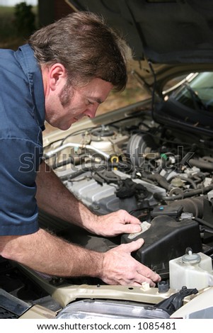 An auto mechanic working on a car.