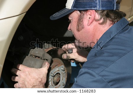 An auto mechanic working on brakes.