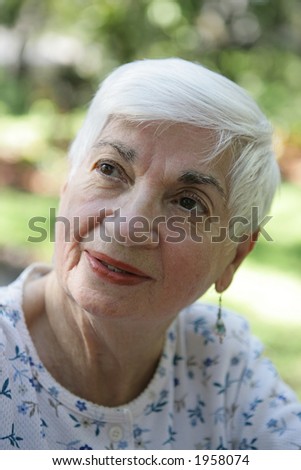 A closeup portrait of a sweet, beautiful grandmother.  Shallow depth of field.