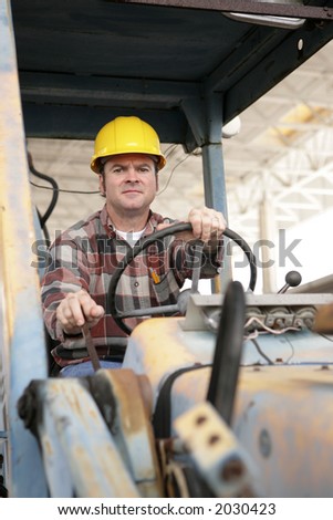 A heavy equipment operator driving a backhoe.