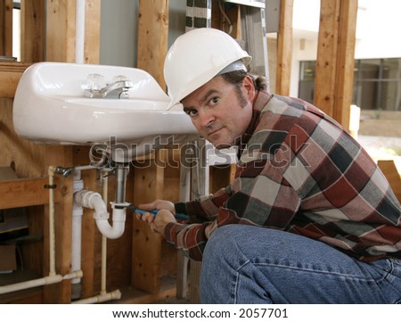A plumber installing fixtures in a construction site.