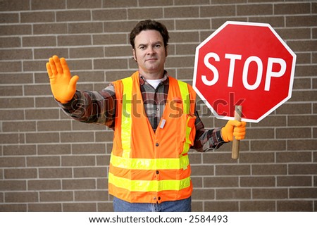 A friendly school crossing guard holding a stop sign.