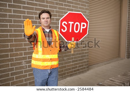 A school crossing guard holding a stop sign.  Room for text.
