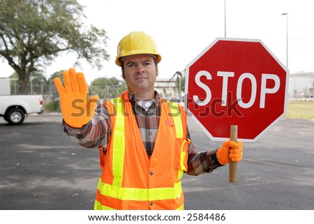 A construction worker holding a STOP sign and directing traffic.