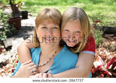 Portrait of a pretty blond mother and daughter in the garden.