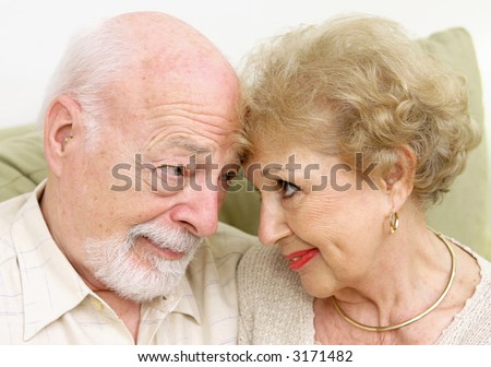 A senior couple looking at each-other lovingly nose to nose.