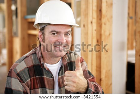 Horizontal view of a construction worker giving a thumbs up.  Authentic construction worker on actual construction site.  Room for text.