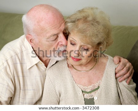 A senior man and wife deeply in love.  She is upset and he is comforting her.