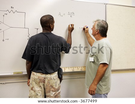 A student and teacher working equations on the board.